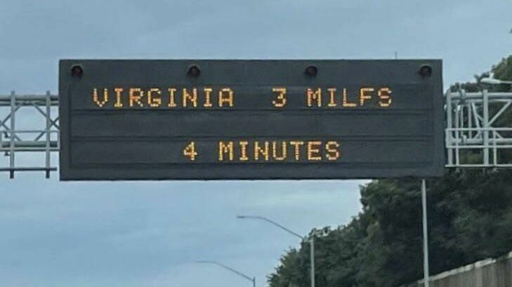 Road sign reads “Virginia / 3 MILFS / 4 MINUTES.”