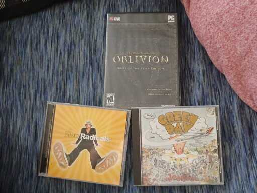 2 CD cases and a PC game case on bedding.